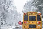 A school bus drives in the snow.